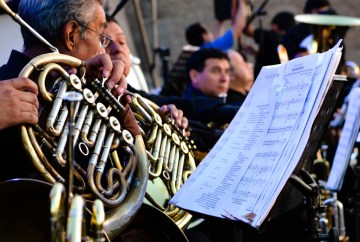 People playing french horns with sheet music