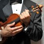 man in tuxedo cradling violin